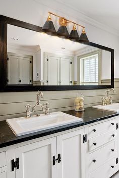 a bathroom with two sinks and a large mirror on the wall above it's counter