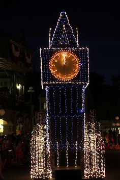 a lighted clock tower in the middle of a street