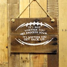 a wooden sign that says it's not whether you get knocked down, it's whether you get back up