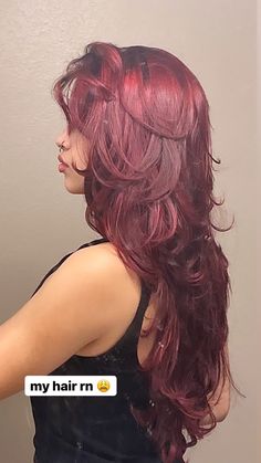 a woman with long red hair is brushing her hair