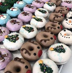 there are many donuts with frosting on them and decorated like snowmen in different colors