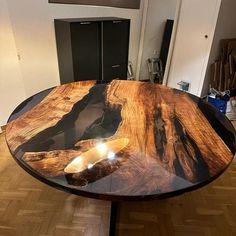 a wooden table sitting on top of a hard wood floor covered in black and brown furniture