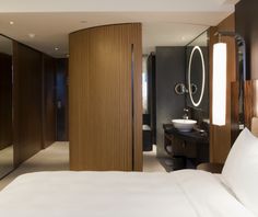 a large bed sitting in a bedroom next to a tall wooden headboard and mirror