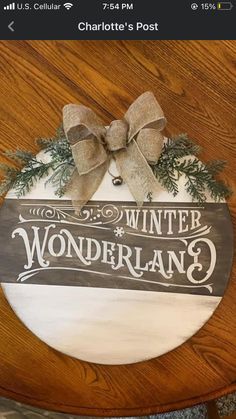 a wooden sign that says winter wonderland on it with a bow hanging from the front