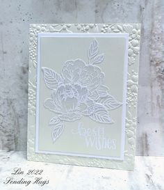 a close up of a greeting card with flowers on the front and bottom, in white