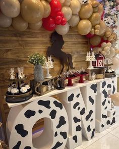 a cow themed birthday party with balloons and decorations