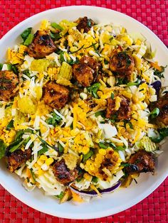 a white bowl filled with food on top of a red table