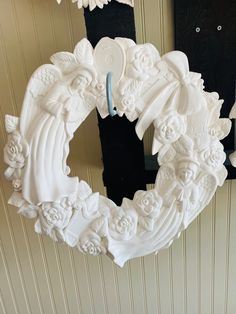 a white wreath hanging from the side of a wall