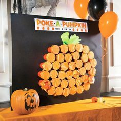 a pumpkin made out of orange slices sitting on top of a table next to balloons