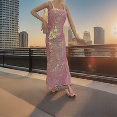 a barbie doll standing on top of a roof next to a cityscape with skyscrapers in the background