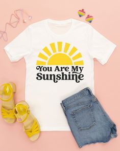 a t - shirt with the words you are my sunshine on it next to sandals and sunglasses