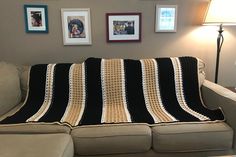 a couch with a black and white crocheted blanket on it's back