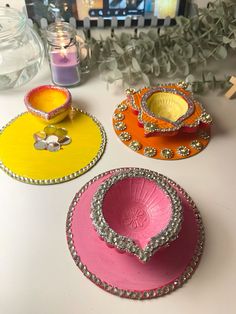 three different colored plates sitting on top of a table next to vases and flowers