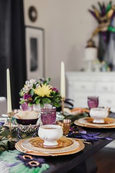 the table is set with dishes, cups and candles