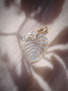 Add to your story with this mother of pearl monstera shell charm. Choose from a regular jump loop or lobster clasp to make it your own.Planning on purchasing a chain for this and need help attaching it? Let us know and leave a note during checkout! This item will arrive separate/detached if no note is left.✦ DETAILS ✦✧ 14kt wire wrapped Mother of Pearl Monstera Shell (26mm x 24mm).✧ 14kt Gold Filled Loop or Clasp✧ Chains sold separately.✧ Due to the nature of the shell, each piece can vary in si White Leaf-shaped Jewelry Gift, Handmade White Leaf-shaped Jewelry, Pearl Shell, 14kt Gold, Your Story, Wire Wrapped, Wire Wrapping, Mother Of Pearl, Lobster Clasp