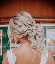 the back of a woman's head, with blonde hair in a low braid