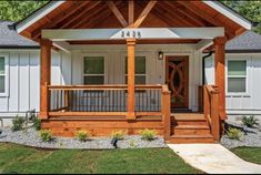 a small white house with wood trim and porch