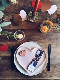 a table set with plates, silverware and candles