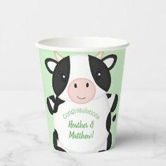 a green and white cup with a black cow on it that says congratulations, mother & me