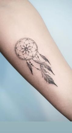 a small dream catcher tattoo on the arm