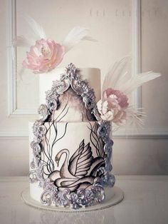 a wedding cake decorated with flowers and feathers