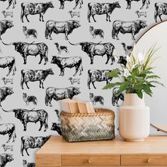 a cow wallpaper with black and white cows on it, next to a plant