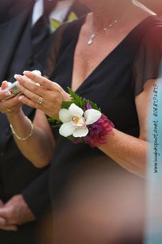 two people standing next to each other with flowers in their hands and one person holding something