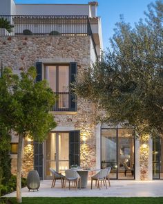 an outdoor dining area in front of a stone building