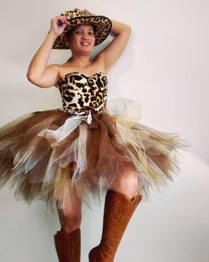 a woman in a leopard print top and brown tutu skirt, with cowboy boots