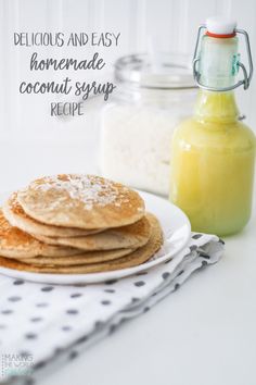 a stack of pancakes sitting on top of a white plate next to a bottle of liquid