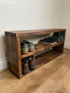 a wooden bench with shoes on it in the middle of a wood flooring area