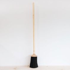 a broom leaning up against a white wall