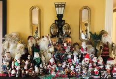 a group of santa clause figurines sitting on top of a mantle next to mirrors