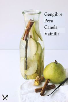 a glass bottle filled with liquid next to an apple and cinnamon