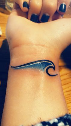 a woman's wrist tattoo with a wave on the left side of her arm