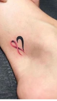 a woman's foot with a tattoo on it that has an image of the word love