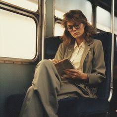 a woman sitting on a train reading a book