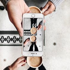 two people holding coffee cups in front of their cell phone, with the screen showing three different images