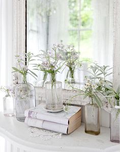 there are flowers in vases and books on the table