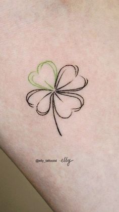 a small four leaf clover tattoo on the back of a woman's left arm