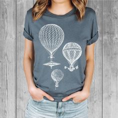 Women's Bella Tri-Blend relaxed unisex fit T-shirt with a Vintage Hot Air Balloons screen printed graphic design.  Super soft, stretchy, and comfy material.   Available with black or white ink! FIT: Follow the image size chart Unisex Fit - Runs Large - Long Length  Suggest sizing down if you prefer a more fitted look instead of relaxed -  Bella 3.8 oz  Super Soft hand and lightweight  -  Tri Blends:  50% Poly, 25%  Cotton, 25%  Rayon -  Does not shrink -  Hand screen printed to order in Oregon - Model is wearing a size small Fashion Fitted Style  http://etsy.me/2qjx3lC ♥ All of our tees are hand-printed to order in our shop in Portland Oregon! ♥ RETURNS & EXCHANGES We gladly accept exchanges and returns if not worn.   Please follow the chest measurement size guide for fit if you are unsure Graphic Tee Crew Neck Top With Printing, Relaxed Fit Crew Neck Top With Printing, Crew Neck Tops With Relaxed Fit And Printing, Relaxed Fit Printed Crew Neck Tops, Graphic Tee Shirt With Crew Neck, Screen Printing Graphic Design, Moon Clothing, Graphic Tees For Women, Vintage Hot Air Balloon