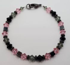 "It is made with 6mm Swarovski Crystals in Light Rose, Black Diamond and Jet, 4mm Hematite Cubes, Gunmetal Turkish Heishi Spacers, Gunmetal Clasp....The bracelet measures 7-1/2\"....Comes in an organza gift bag." Pink Swarovski, Swarovski Bracelet, Light Rose, Rose Black, Rose Lights, Organza Gift Bags, Pink Bracelet, Dream Jewelry, Diy Bracelets