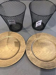 three gold plates and two black wire baskets