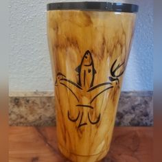 a wooden cup sitting on top of a counter next to a white wall and floor