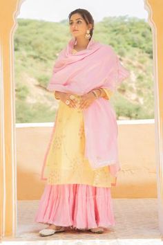 Yellow chanderi kurta with gota jaal detailing on the neckline, sleeves and hemline. Comes with light pink dupatta adorned with gota flowers and ghera sharara in soft mul mul adorned with gota detailing.
Component: 3
Embroidered
Neckline: V Neck
Sleeve Length: Three Quarter
Fabric: Kurta and Dupatta: Chanderi; Pant: Mul Mul
Color: Yellow,Pink
Gota trims
Side slits
Gathered tiers
 - Aza Fashions Yellow Indian Suit, Yellow Haldi Outfit, Pant Embroidery, Chicken Suits, Pink Sharara, Kurta And Dupatta, Rain Dance, Yellow Kurta, Chanderi Dupatta