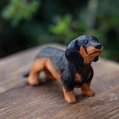 a toy dachshund dog is sitting on a wooden table