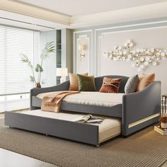 a living room scene with focus on the daybed and pillows in the foreground