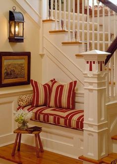 there is a red and white striped couch on the stairs