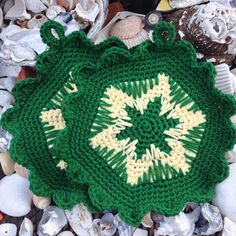 a green crocheted doily sitting on top of seashells