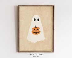 a halloween ghost with a pumpkin on it's face is hanging from a wall